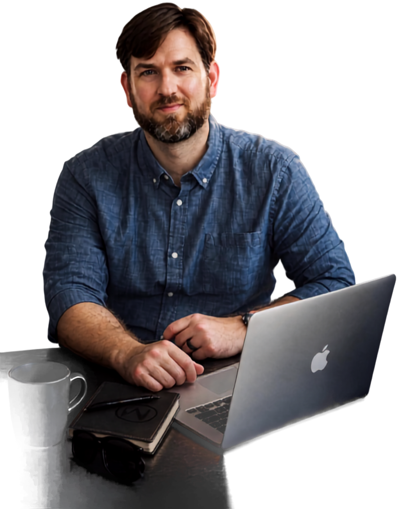 Paul David Thompson at his desk with a laptop, notebook, and mug